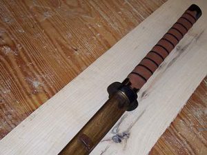 Wooden katana on wooden surface.
