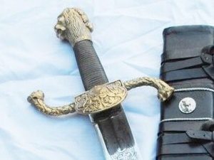 Ornate sword with sheath on fabric background.