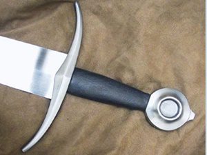 Medieval sword on brown fabric background.