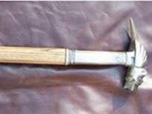 Metal hammer with wooden handle on fabric.