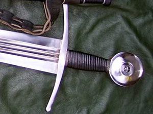 Medieval sword with black grip on leather.