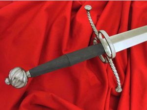 Silver-hilted rapier on draped red cloth