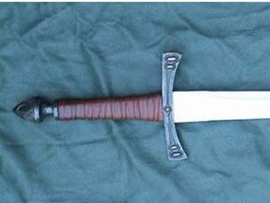 Medieval sword hilt on blue fabric.