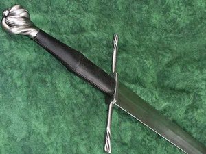 Medieval sword with ornate hilt on display.