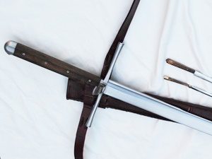 Sword with leather sheath on white background.