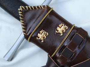 Sword with ornate brown leather scabbard.