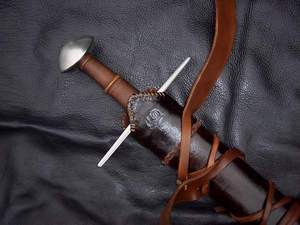 Leather sheath holding a dagger with a wooden handle and a leather strap.