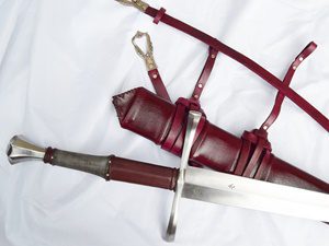 Sword with red leather scabbard and belt.