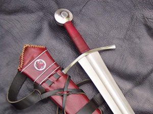 Medieval sword with red scabbard on leather.