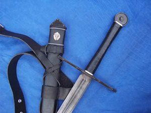 Sword with black scabbard on blue fabric.