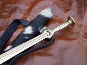 Sword with sheath on leather surface.