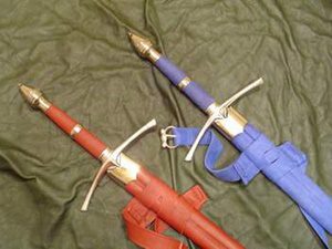 Red and blue sheathed swords on green cloth