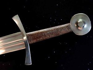 Medieval sword hilt against dark background.