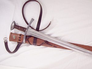 metal sword with leather scabbard on white