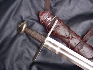 Medieval sword and sheath on dark fabric.