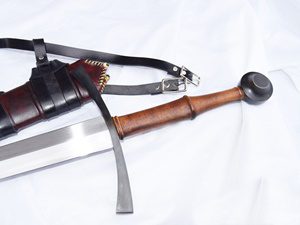 Medieval sword and leather scabbard on fabric.