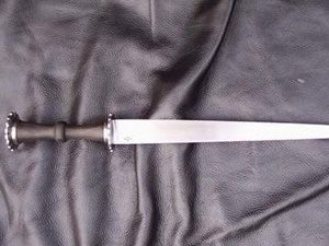 Short sword on black leather background.