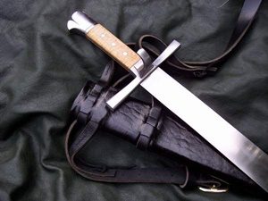 Sword with leather sheath on fabric background.