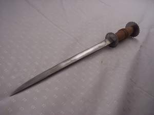 Vintage knife with a wooden handle lying on a white surface.