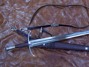 Medieval sword with leather scabbard on leather.