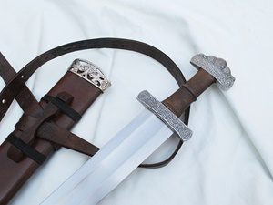 Medieval sword and sheath on white fabric.