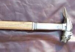 Metal hammer with wooden handle on fabric.
